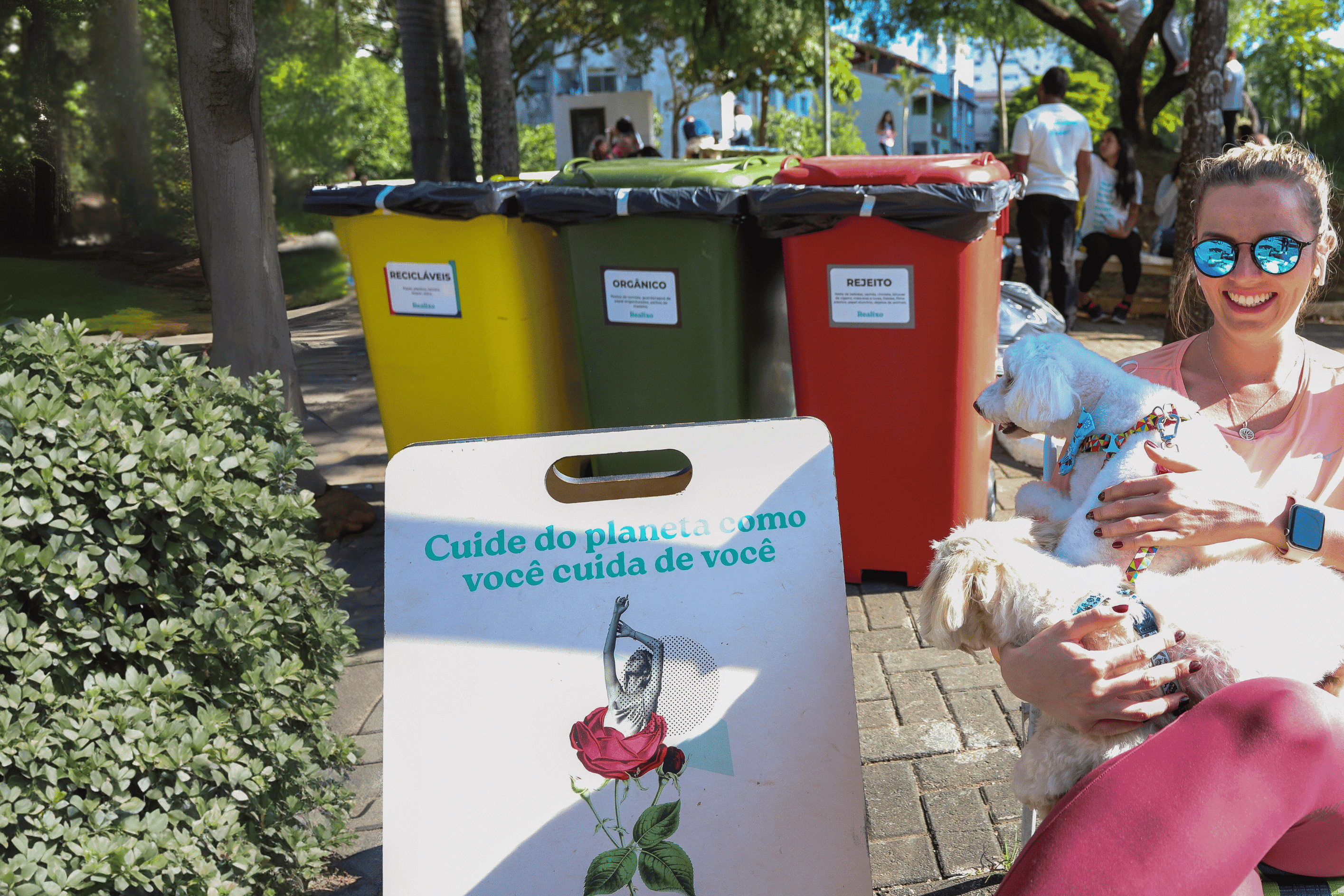 lixeiras reciclaveis com mulher e cachorro